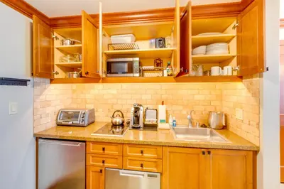 a kitchen with wooden cabinets and a sink at Pool and Hot Tub Access! Condo in Olympic Valley in Olympic Valley