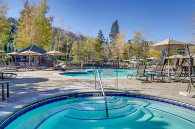 a pool at a resort with chairs and umbrellas at Pool and Hot Tub Access! Condo in Olympic Valley in Olympic Valley