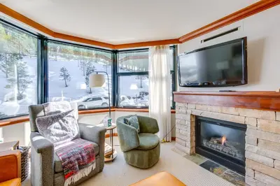 a living room with a fireplace and a flat screen tv at Pool and Hot Tub Access! Condo in Olympic Valley in Olympic Valley