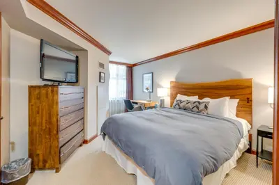 a bedroom with a large bed and a flat screen tv at Pool and Hot Tub Access! Condo in Olympic Valley in Olympic Valley