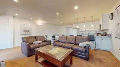 a living room with a couch and a table and a kitchen at Lakeview Villas #24 condo in Mammoth Lakes