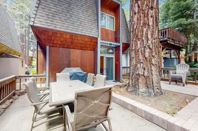 a patio with a table and chairs next to a tree at The Great Escape in Incline Village