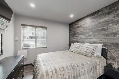 a bedroom with a bed and a wooden wall at Modern Mountain Retreat in Incline Village