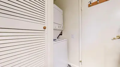 a kitchen with a washer and dryer next to a door at Lakeview Villas #26 condo in Mammoth Lakes