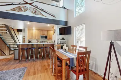 a kitchen with a wooden table and bar with chairs at Kingswood Village #167 in Kings Beach