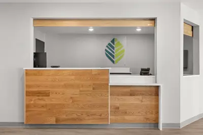 an office with a desk with a green and white sign on a wall at WoodSpring Suites Ceres - Modesto in Ceres