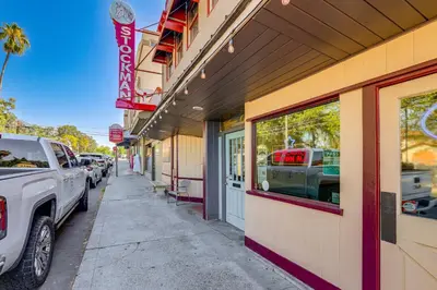 a building with cars parked on the side of a street at Downtown Fair Oaks Home about 15 Mi to Sacramento! in Fair Oaks