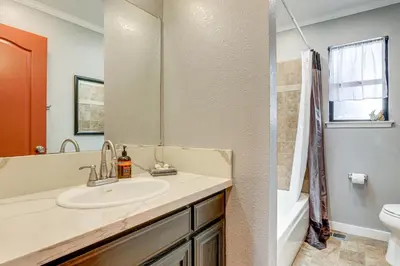 a bathroom with a sink and a toilet and a mirror at Downtown Fair Oaks Home about 15 Mi to Sacramento! in Fair Oaks