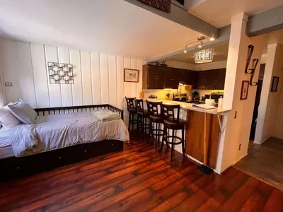 a bedroom with a bed and a kitchen with a counter at Walk-to-Lifts Condo with Hot Tub, Dog Friendly in Mammoth Lakes