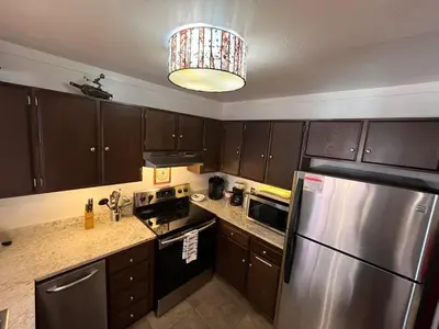 a kitchen with wooden cabinets and a stainless steel refrigerator at Walk-to-Lifts Condo with Hot Tub, Dog Friendly in Mammoth Lakes