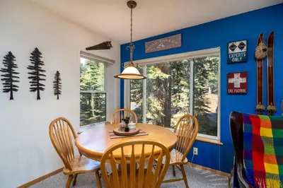 a dining room with a wooden table and chairs at Cozy Corner Tamarack Condo 19 in Tamarack