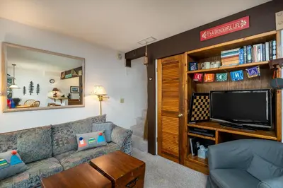 a living room with a couch and a tv at Cozy Corner Tamarack Condo 19 in Tamarack