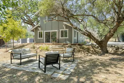a house with a table and chairs in front of it at The River House in Three Rivers