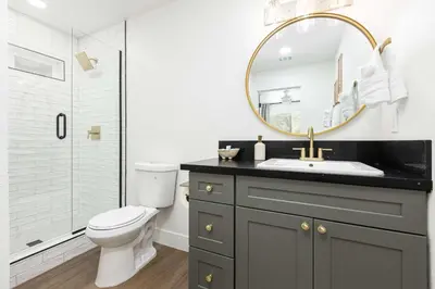 a bathroom with a sink and a toilet and a mirror at The River House in Three Rivers