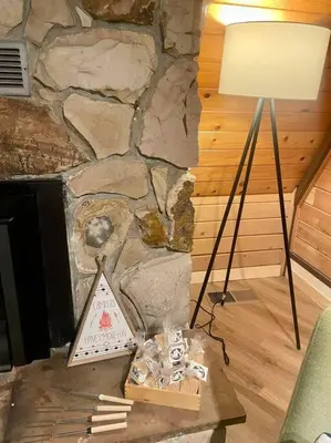 a table with a lamp and a stone wall at Cozy Chalet - Hot Tub with Meadow Views - Family & Pets, Fire Pit & BBQ in Arnold