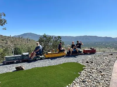 a group of people riding on a miniature train at Enchanted Property near Yosemite, View, Game Room in Ahwahnee