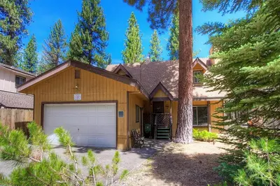 a house with a garage and a tree at Bambi's Bunkhouse home in South Lake Tahoe