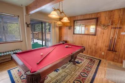 a room with a pool table in a room with wooden walls at Bambi's Bunkhouse home in South Lake Tahoe