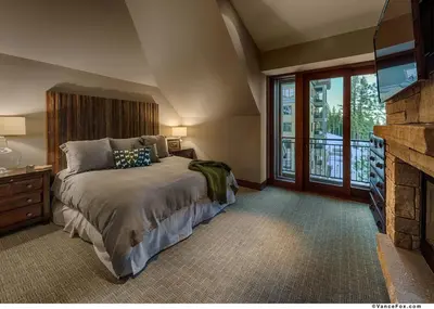 a bedroom with a large bed and a fireplace at Penthouse Residence The Ritz-Carlton Lake Tahoe in Truckee