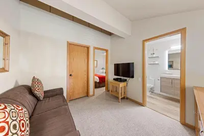 a living room with a couch and a bedroom at Palisades Tahoe Lodge Rentals Studio Loft #356 in Olympic Valley