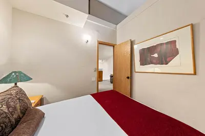 a hotel room with a bed and a lamp at Palisades Tahoe Lodge Rentals Studio Loft #356 in Olympic Valley