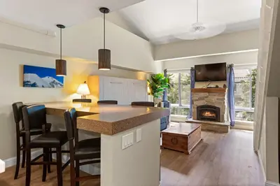 a kitchen and living room with a fireplace at Palisades Tahoe Lodge Rentals Premium Studio Loft #336 in Olympic Valley