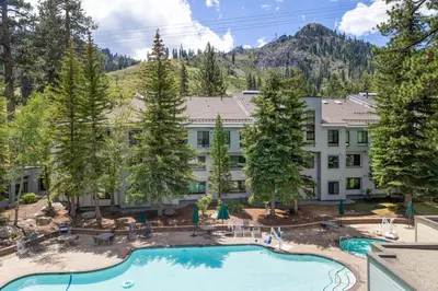 an aerial view of a resort with a pool and trees at Palisades Tahoe Lodge Rentals Premium Studio Loft #336 in Olympic Valley