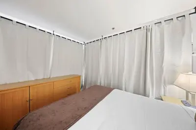a bedroom with a bed and a dresser and curtains at Palisades Tahoe Lodge Rentals Studio Loft #346 in Olympic Valley
