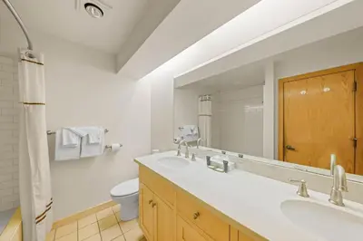 a bathroom with a sink and a toilet and a mirror at Palisades Tahoe Lodge Rentals Studio Loft #346 in Olympic Valley