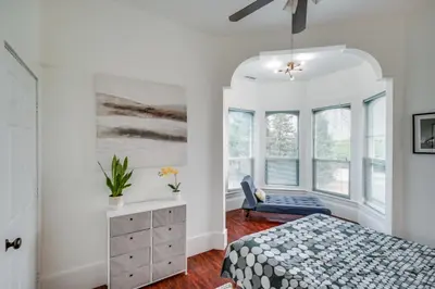 a bedroom with a bed and a dresser and windows at Modesto Mansion on 2 Acres - Great for Families! in Modesto