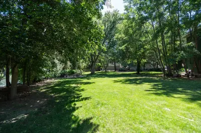a park with trees and green grass and buildings at Truckee River Ranch in Reno