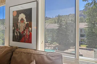 a living room with a window with a painting on it at Palisades Tahoe Lodge Rentals Studio Loft #338 in Olympic Valley