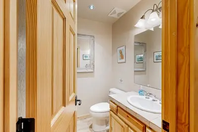 a bathroom with a sink and a toilet and a mirror at Spacious Deck with Private Hot Tub Kings Beach Gem in Wood Vista