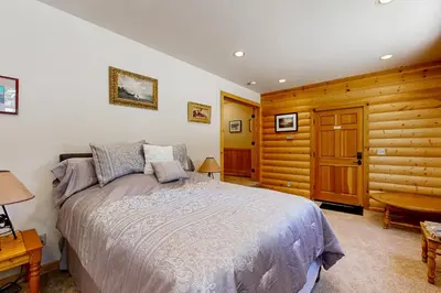 a bedroom with a bed and a wooden wall at Spacious Deck with Private Hot Tub Kings Beach Gem in Wood Vista