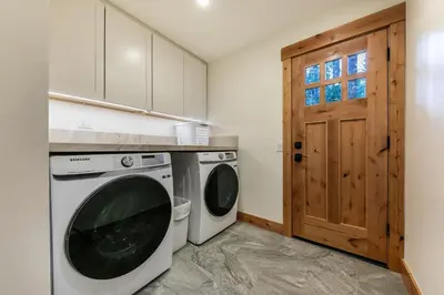 a laundry room with a washing machine and a door at Eclipse Retreat at Tahoe Park - Hot Tub - Fenced Yard & steps to HOA Access in Tahoe City
