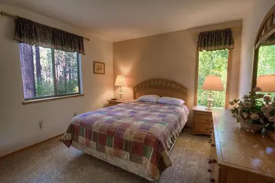 a bedroom with a bed and two windows at Aspen View Lodge home in South Lake Tahoe