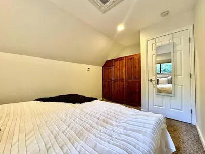 a bedroom with a white bed and a window at Cabin in the Trees-Game Room in Pollock Pines
