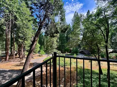 a balcony with a fence and some trees at Cabin in the Trees-Game Room in Pollock Pines
