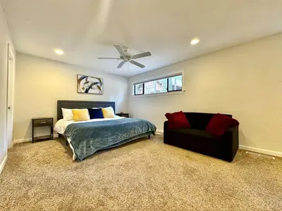 a bedroom with a bed and a couch and a ceiling fan at Cabin in the Trees-Game Room in Pollock Pines