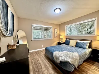 a bedroom with a blue bed and two windows at Foothill Wine Country Gem in Somerset