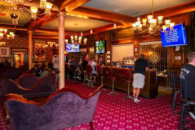 a bar with people sitting in chairs in a restaurant at Mizpah Hotel in Tonopah