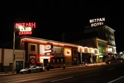 a city street at night with neon signs at Mizpah Hotel in Tonopah