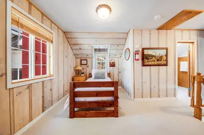a room with wooden walls and a bedroom with a bed at Alpine Cottage Hideaway in Stateline