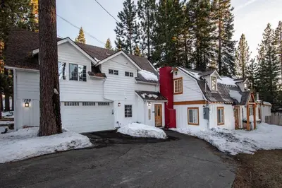 a white house with a garage in the snow at Alpine Cottage Hideaway in Stateline