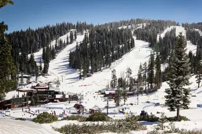 a snow covered ski slope with people on it at Bright 3BR Condo Near Northstar in Truckee