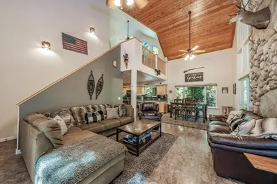 a living room with couches and a staircase at Cabin at the Creek Family Fun Starts Here! in Shaver Lake
