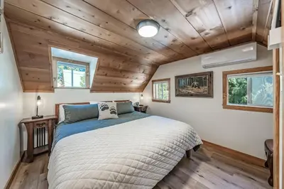 a bedroom with a bed in a room with wooden ceilings at Buckeye Bear's Den-AC-Walking Distance to town in Shaver Lake