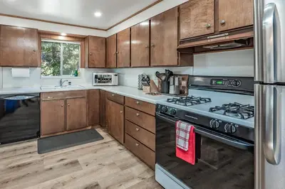 a kitchen with wooden cabinets and a stove top oven at Buckeye Bear's Den-AC-Walking Distance to town in Shaver Lake
