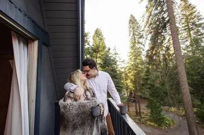 a man and woman kissing on a balcony at Dogwood Peak Mid-Century A-Frame with AC Style in Shaver Lake