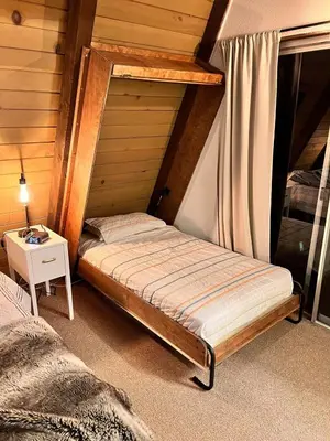 a bedroom with a bed and a side table at Dogwood Peak Mid-Century A-Frame with AC Style in Shaver Lake